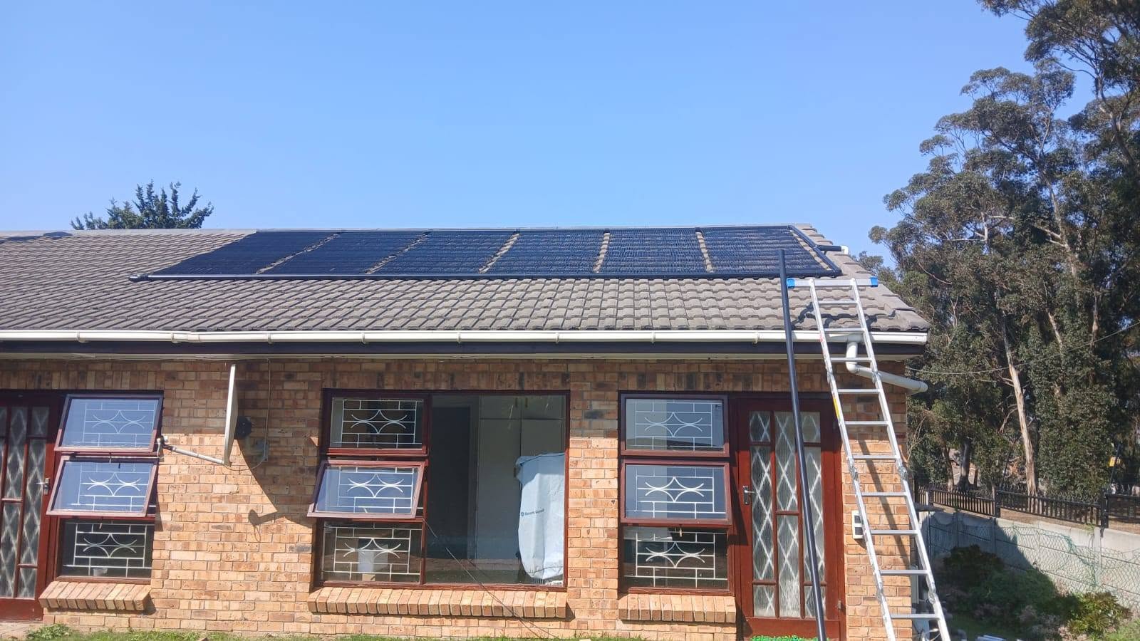 Solar pool heating panels on a Western Cape home with mountain views